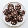 A plate of chocolate cookies with milk and white chocolate chips